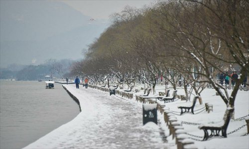 Tourists wonder by the West Lake after a snowfall in Hangzhou, capital of east China's Zhejiang Province, Feb. 8, 2013. A big range of snowfall enveloped Zhejiang Province on Friday. Photo: Xinhua