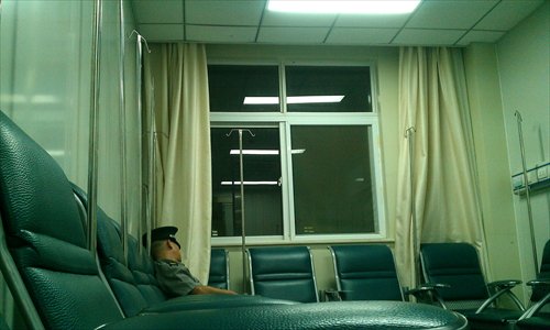 A security guard dozes in a hospital; many security guards in Shanghai hospitals are low-paid and lack training. Photo: CFP 