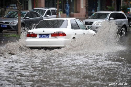 A motorcar runs on a flooded road in Taiyuan, capital of North China's Shanxi Province, July 31, 2012. A downpour hit the city on Tuesday morning and caused urban waterlogging. Photo: Xinhua