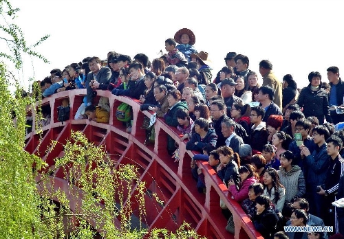  Tourists look out from a bridge at a scenic spot in Kaifeng, central China's Henan Province, April 6, 2013. Many scenic spots around Kaifeng were overcrowded by visitors who came to enjoy leisure time during the Qingming Festival holiday. (Xinhua/Wang Song)  