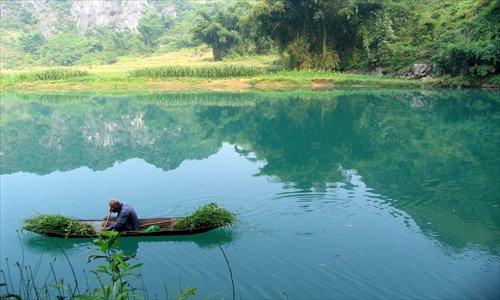 A man sails on a boat in Bama county, in the Guangxi Zhuang Autonomous Region in September, 2006. Photo: CFP