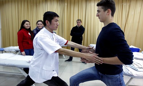 A Chinese instructor shows students the correct posture for tuina massage therapy. Photos: Yang Hui/GT