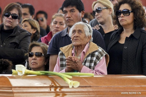 Relatives and friends stand beside the coffins of victims of a fireworks accident during a mass funeral at the village of Nativitas in Tlaxcala state, Mexico, on March 17, 2013. At least 13 people were killed and 154 others injured when a truck containing fireworks exploded during a Catholic procession in honor of a local patron saint. (Xinhua/Juan Mateo) 