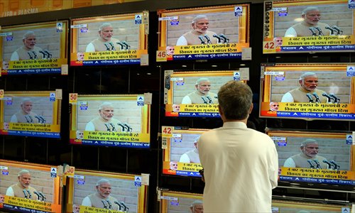 Indian resident Maqbool Alam Siddiqui watches a bank of televisions featuring images of Modi taking his oath as prime minister in New Delhi at an electronic showroom in Mumbai on Monday.