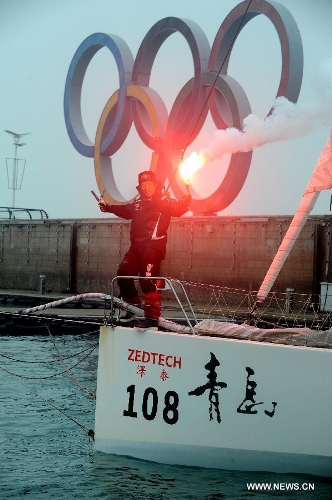 China's Guo Chuan celebrates after returning home in Qingdao, east China's Shandong Province, April 5, 2013. Guo sailed back home on Friday morning to become the first Chinese to successfully circumnavigate the globe singlehanded. Aboard his Class40 yacht, 48-year-old Guo travelled about 21,600 nautical miles in 138 days before he returned to his hometown of Qingdao, where he set off on November 18 last year. (Xinhua/Li Ziheng) 