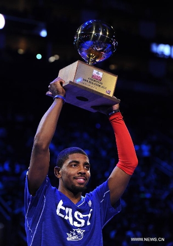 Kyrie Irving of Cleveland Cavaliers holds up his trophy after winning the three point contest part of 2013 NBA All-Star Weekend at the Toyota Center in Houston, the United States, Feb. 16, 2013. (Xinhua/Yang Lei) 