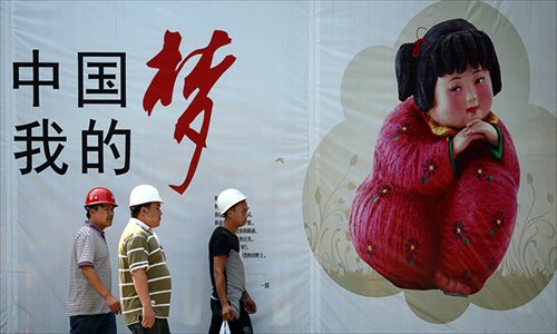 Chinese workers walk past a 