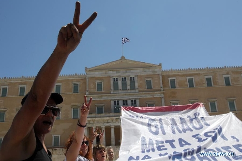  Protesters shout slogans and hold banners in front of the House of Parliament, in Athens, Greece, May 1, 2013. Greece is in the grip of a new 24-hour general strike on Wednesday, as the country's largest unions of public and private sector workers ADEDY and GSEE mark Labor Day with anti-austerity rallies in central Athens and other major cities. (Xinhua/Marios Lolos)  