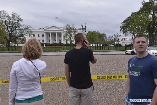 People watch the White House near a cordon outside the building in Washington D.C., capital of the United States, April 15, 2013. The White House increased security, and the Justice Department and FBI mobilized to fully investigate the explosions occurring near the Boston Marathon finish line today. (Xinhua/Zhang Jun) 