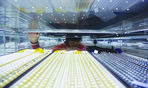 A customer looks at pearl necklaces in a store in Zhuji, Zhejiang Province Tuesday. The city currently produces more than 70 percent of the world's freshwater pearls, and its pearl industry generated a revenue of 503 million yuan ($80.5 million) in the first half of 2012, up 66 percent from the same period a year earlier, people.com.cn reported Tuesday. Photo: CFP 