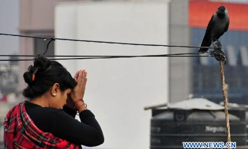 A Nepalese woman worships a crow during 