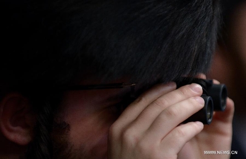 A Jewish man of the Belz Hasidic Dynasty uses a binocular to watch the wedding ceremony of Rabbi Shalom Rokeach, the grandson of the Belz Rabbi Yissachar Dov Rokeach, at the neighbourhood of Kiryat Belz in Jerusalem on May 21, 2013. More than 10,000 Jews participated in the wedding. (Xinhua/Yin Dongxun) 