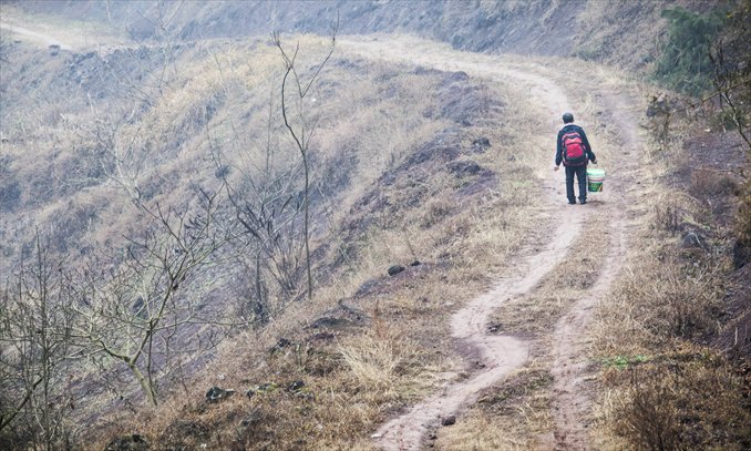 Wang Shanyun, 61, walks toward his home in the mountainous village of Yongli in Kaixian county, Chongqing on February 1.