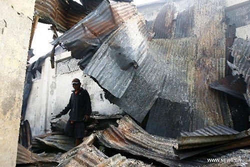 A man looks for reuseable materials at his charred home after a fire hit a residential area in Valenzuela City, the Philippines, Feb. 19, 2013. Around 500 houses were razed in the fire, leaving 2,000 residents homeless. (Xinhua/Rouelle Umali) 