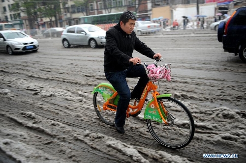 A man rides on a snowy road in Taiyuan, capital of north China's Shanxi Province, April 19, 2013. The city witnessed a snowfall on Friday. (Xinhua/Yan Yan)