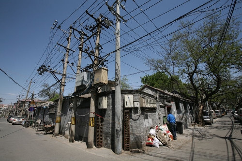 Hutongs aligned alongside one another(Photo: CRIENGLISH.com/ Wang Zhi)A Hutong is a traditional alley, characteristic of an old Beijing city. A total of 7000 Hutongs have been built throughout the capital in straight lines under strict construction guildlines. The longest Hutong starts from the Beijing Legation Quarter, Dong Jiao Min Xiang,to the Xijiao Min Xiang, and has a total length of 6.5 kilometers, while the shortest Hutong is One-inch Street at only several meters' long. The narrowest Hutong is only about 0.7 meters wide. Therefore, people carrying even a little bit of extra weight have to hold their breath to pass through it. Formed during the Yuan, Ming and Qing, dynasties thousands of Hutongs surround the supreme Imperial Palace from all directions. They are woven into the fabric of people's daily lives.