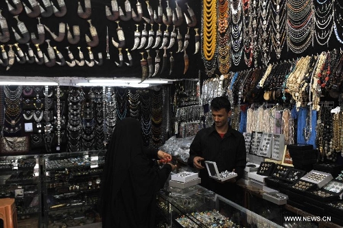 A vendor talks with a customer at his shop in the Old City of Sanaa, Yemen, on March 24, 2013. According to local media, Yemen's tourism sector suffered losses estimated at one billion U.S. dollars following the 2011 crisis. Vendors in the Old City of Sanaa, a UNESCO World Heritage Site, said the number of foreign tourists declined by at least 90 percent due to the 2011 unrest that severely undermines security in Yemen. (Xinhua/Mohammed Mohammed) 