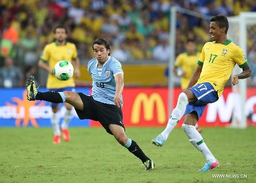 Brazil's Luiz Gustavo (R) vies for the ball with Alvaro Gonzalez (L) of Uruguay, during the FIFA's Confederations Cup Brazil 2013 semifinal match, held at Mineirao Stadium, in Belo Horizonte, Minas Gerais state, Brazil, on June 26, 2013. (Xinhua/Liao Yujie)