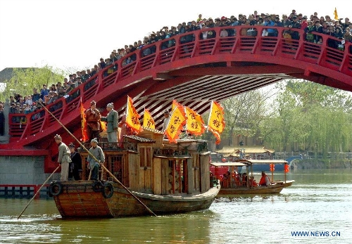  Tourists gather on a bridge to look at performance on a river in a scenic spot in Kaifeng, central China's Henan Province, April 6, 2013. Many scenic spots around Kaifeng were overcrowded by visitors who came to enjoy leisure time during the Qingming Festival holiday. (Xinhua/Wang Song)  