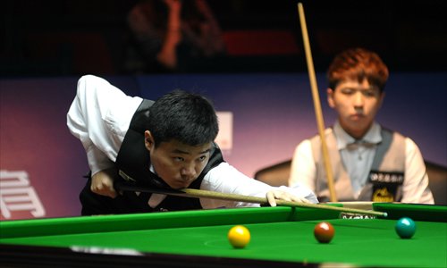 China's Ding Junhui (left) lines up a shot as his rival, compatriot Xiao Guodong, watches during their final snooker match of the Bank of Communications Shanghai Masters in Shanghai on Sunday. This was the first-ever world ranking final between two Chinese players. Ding won the best-of-19 clash 10-6. Photo: IC