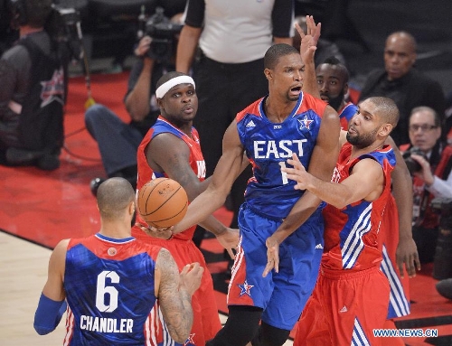 Chris Bosh (C) of the Miami Heat and the Eastern Conference breaks through during the 2013 NBA All-Star game at the Toyota Center in Houston, the United States, Feb. 17, 2013. (Xinhua/Zhang Jun) 