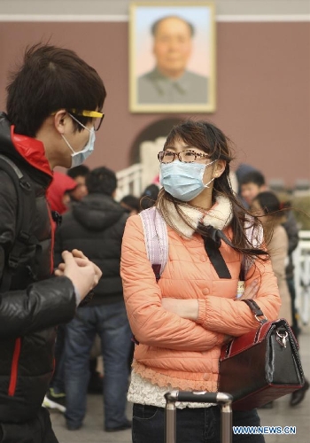 Two masked tourists are seen at the Tian'anmen in Beijing, capital of China, Feb. 28, 2013. Beijing was hit by heavy fog on Thursday morning. The fog led to reduced visibility and degenerated air quality. The city also issued high wind and haze alerts on the same day. (Xinhua/Liu Changlong) 