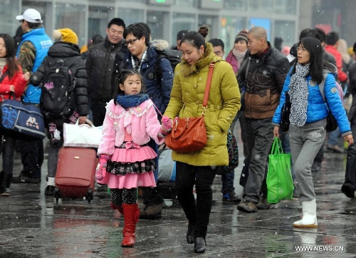 A girl walks with her mother at the Beijing West Railway Station in Beijing, capital of China, Feb. 3, 2013. Many children travel with their families during the 40-day Spring Festival travel rush which started on Jan. 26. (Xinhua/Chen Shugen)  