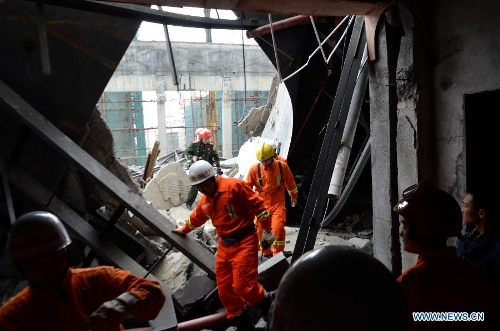 Rescuers search for the trapped workers after a collapse accident happened in a hotel under construction in Zixing City, central China's Hunan Province, March 27, 2013. Two men remained buried in the rubble of a collapsed wall of the hotel. The accident occurred Wednesday morning, when the wall of a dining hall in the hotel collapsed, burying six construction workers. Four workers have been rescued and sent to the hospital, including one worker with serious injuries. (Xinhua/He Maofeng) 