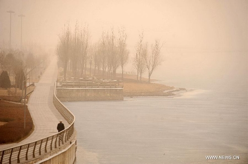 A man walks on a walking path in Taiyuan, capital of north China's Shanxi Province, Feb. 28, 2013. Pollution worsened in China's north and east provinces as a sand storm hit the region on Thursday. (Xinhua/Zhan Yan) 