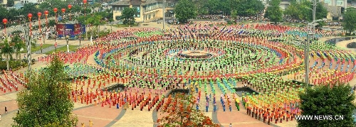   People gather on a square performing a traditional umbrella dance to celebrate the Water Splashing Festival, also the New Year of the Dai ethnic group, in Jinghong City, Dai Autonomous Prefecture of Xishuangbanna, southwest China's Yunnan Province, April 14, 2013. (Xinhua/Qin Qing)  