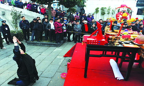 A woman pays wholehearted tribute to the God of Wealth in Jiaxing, Zhejiang Province, on Friday. Photo:CFP