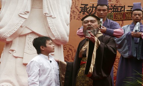 A performer dressed in Confucian style offers a young boy guidance. Photo: Courtesy of Jiading District Tourism Bureau