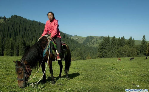 A girl of the Kazakh ethnic group rides horse on the Narat Grasslands in Xinyuan county, northwest China's Xinjiang Uyghur Autonomous Region, August 22, 2012. Photo: Xinhua