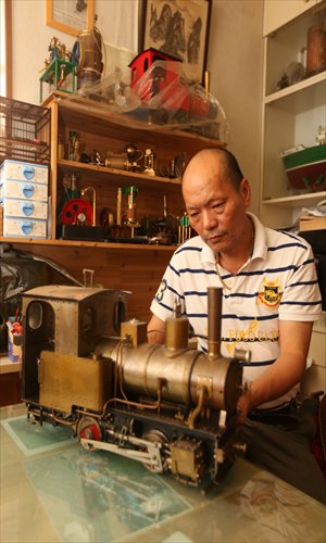 Shanghai-born Lu Jiming poses with one of his miniature passenger-pulling, steam-engine trains Photos: Cai Xianmin/GT