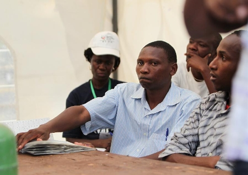  A staff worker presses ballot papers with his hand at a counting station in Nairobi, Kenya, March 4, 2013. Millions of Kenyans turned up early Monday to vote in the historic general elections after independence and in the first national exercise under new constitution after the a disputed polls in 2007. According to the constitution, Kenya's Independent Electoral and Boundaries Commission (IEBC) will have seven days to officially announce the results, but the country's next president is expected to be known by Monday evening or Tuesday. (Xinhua/Meng Chenguang) 