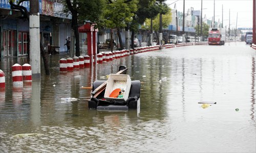 On Jinchang Road a manhole cover was opened to speed drainage and an old sofa was placed on top as a warning for pedestrians. Photo: Cai Xianmin/GT
