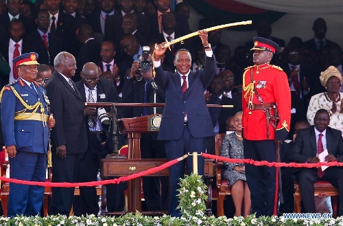 Uhuru Kenyatta lifts up the Commander-in-Chief ceremonial sword received from former President Mwai Kibaki (2nd L, front) during the inauguration ceremony at Moi International Sports Center in Nairobi, capital of Kenya, April 9, 2013. Kenya's President Uhuru Kenyatta officially took office on Tuesday after being sworn into office as the East African nation's fourth president. (Xinhua/Meng Chenguang)