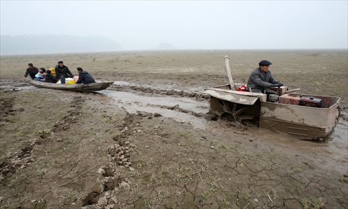 An improvised amphibious tractor tugs a family's flat bottom boat.Photo: CFP