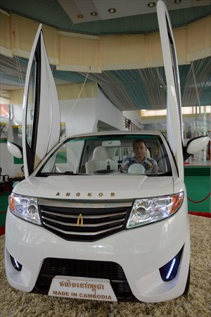 Cambodian mechanic Nhean Phaloek sits in a locally made electric car,  the Angkor EV 2013, at a showroom in Phnom Penh on Tuesday. It is the first electric-powered car for Cambodia's Heng Development Company. Photo: AFP