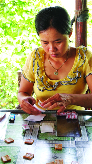 A woman on one of the Mekong Islands making coconut candy.
