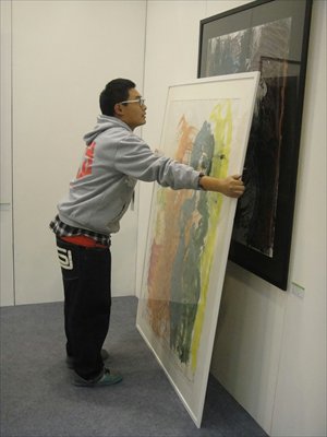 A vendor displays a painting for sale at the Art China fair on Sunday at the Agricultural Exhibition Center. Photo: Jack Aldane/GT