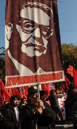 A protester holds a banner during a protest called by the Worker's United Center (CUT, by its Spanish acronym), The School of Teachers, and social organizations, in Valparaiso, Chile, on May 21, 2013. The protest was performed simultaneously with the delivery of the last management report by president Sebastian Pinera before Chile's National Congress. (Xinhua/Jorge Villegas) 