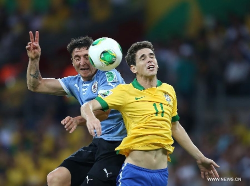 Brazil's Oscar (R) vies for the ball with Cristian Rodriguez (L) of Uruguay, during the FIFA's Confederations Cup Brazil 2013 semifinal match, held at Mineirao Stadium, in Belo Horizonte, Minas Gerais state, Brazil, on June 26, 2013. (Xinhua/Liao Yujie)