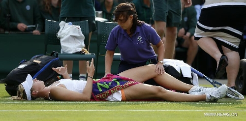 Maria Sharapova of Russia receives medical treatment during the second round of women's singles against Michelle Larcher De Brito of Portugal on day 3 of the Wimbledon Lawn Tennis Championships at the All England Lawn Tennis and Croquet Club in London, Britain on June 26, 2013. Maria Sharapova lost 0-2. (Xinhua/Wang Lili) 