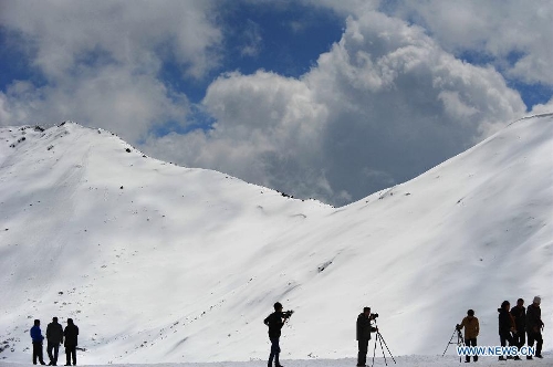 Photo taken on April 15, 2013 shows a line of visitors at the foot of a snow mountain in Nyingchi Prefecture, southwest China's Tibet Autonomous Region. (Xinhua/Wen Tao) 