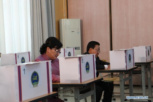 Mongolian President Tsakhia Elbegdorj (R) and his wife fill in their ballots before voting at a polling station in Ulan Bator, Mongolia, June 26, 2013. Mongolian voters began to vote for a new president on Wednesday, with incumbent President Tsakhia Elbegdorj widely expected to be reelected. (Xinhua/Shi Yongchun)