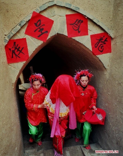  A bride (C) with a red cloth on the head walks along a corridor to her wedding ceremony in Zhangbian Township of Shanxian County, central China's Henan Province, Feb. 9, 2000. People who live in the central China region usually hold wedding ceremonies during the festive Spring Festival period. (Xinhua/Wang Song) 