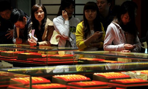 Consumers wait in a line to check out at a gold jewellery shop in Nanjing, capital of east China's Jiangsu Province, April 18, 2013. Gold jewellery shops through China have lowered price of gold jewellery due to the consecutive decline of gold price global markets recently, which boost sales in these shops. Photo: Xinhua