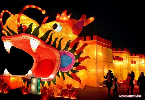  People walk past lanterns at a lantern fair in Zehngzhou, capital of central China's Henan Province, Jan. 26, 2012. Chinese people has a tradition to enjoy lanterns during the Lantern Festival which falls on the 15th day of the first lunar month. (Xinhua/Wang Song)