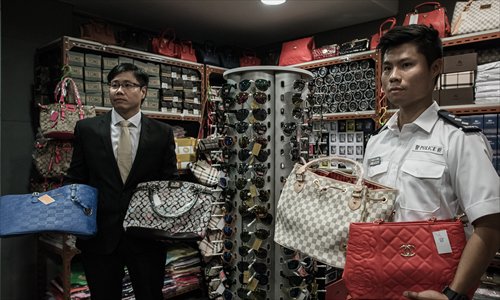 FILE--A Chinese police officer and workers confiscate fake Louis Vuitton  handbags at a warehouse in Guangzhou city, south Chinas Guangdong province  Stock Photo - Alamy
